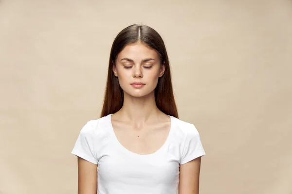 Bella donna occhi chiusi bianco t-shirt sfondo beige — Foto Stock