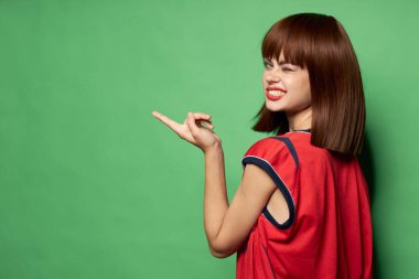 Kadın kameraya göz kırpar ve parmağını yana çevirir.