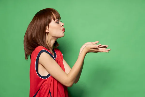 Frau im roten T-Shirt bläst einen Kuss Seitenansicht auf isolierten Hintergrund — Stockfoto