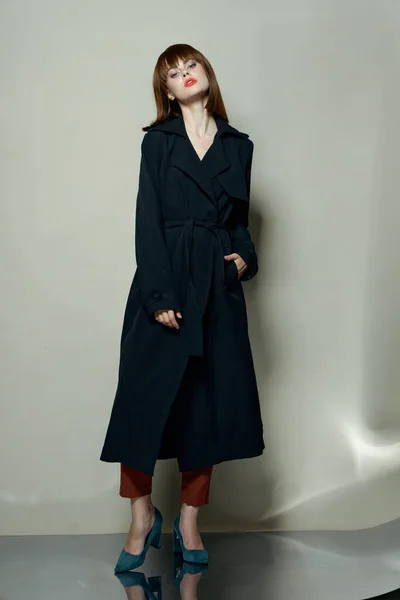 Mulher modelo em um casaco preto em um fundo isolado — Fotografia de Stock