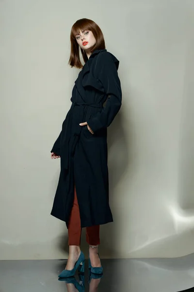 Modelo mulher confiante em sapatos de salto alto casaco preto — Fotografia de Stock