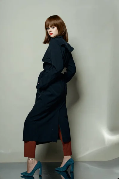검은 코트를 입고 굽 이 높은 구두를 공짜로 신는 유행하는 여자 — 스톡 사진