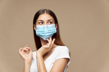 Tıbbi maske takmış beyaz gömlekli güzel bir kadın. 