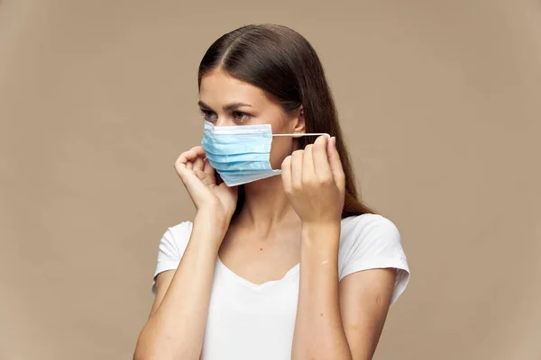 Ung kvinna i vit skjorta i en skyddande mask allergi — Stockfoto