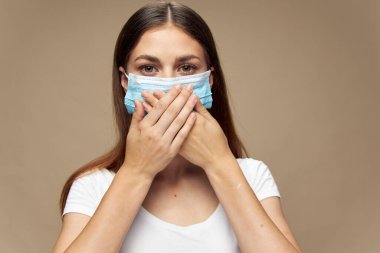 Tıbbi maske takan şık elbiseli güzel bir kadın. 