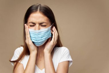 Güzel bir kadın koruyucu maske takarak şık kıyafetler giyer. 