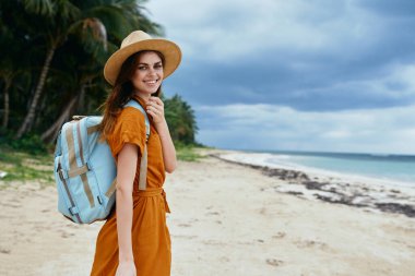 Neşeli kadın turist sırt çantasıyla sahil adasına gidiyor. 