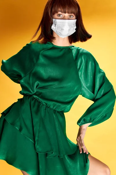 女性でファッションドレスポーズで医療マスクウイルスcovid-19 — ストック写真