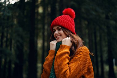 Kırmızı şapkalı ve turuncu kazaklı bir gezgin boynuna atkı dolamış. 