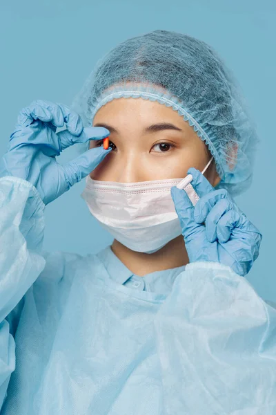 Žena lékař s lékařskou maskou ruce drží antibiotika — Stock fotografie