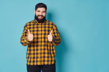  Adam başparmağını gösterir ve kameraya güler. Boş bir alan.
