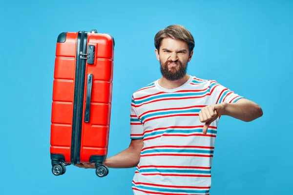 Man with red suitcase showing negative hand gesture — Stock Photo, Image