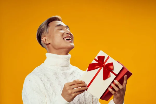 하얀 스웨터를 입고 즐거운 휴일 생활을 즐기는 크리스마스 남자를 위한 선물 — 스톡 사진