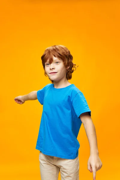 青いTシャツと軽めのズボンを着た赤い髪の男の子 — ストック写真
