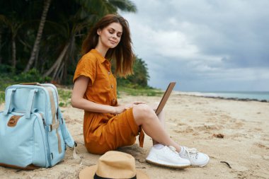 Adada dizüstü bilgisayarı olan bir kadın sırt çantasıyla internet gezisi teknolojisi kullanıyor. 