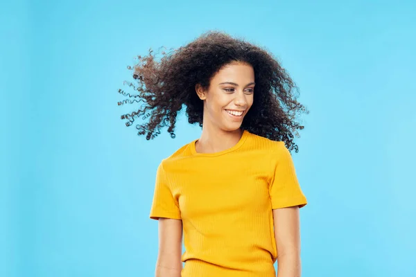 Femme gaie avec cheveux bouclés afro coiffure en t-shirt jaune look attrayant sourire — Photo