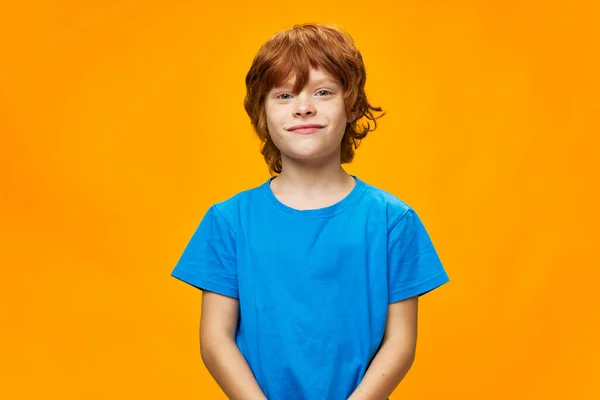 Red hair handsome boy blue t-shirt yellow background — Stock Photo, Image