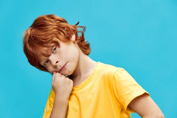 Rudowłosy chłopiec z nudnym wyrazem twarzy pochylonym na bok — Zdjęcie stockowe