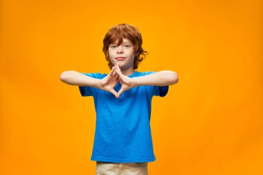 Güzel kızıl saçlı çocuk parmaklarını birleştirdi. 