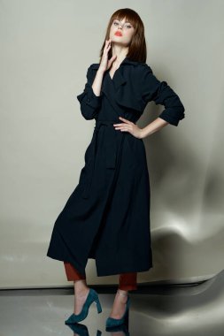 Zarif model siyah pelerin, disko saç stili. Güzel yüz.