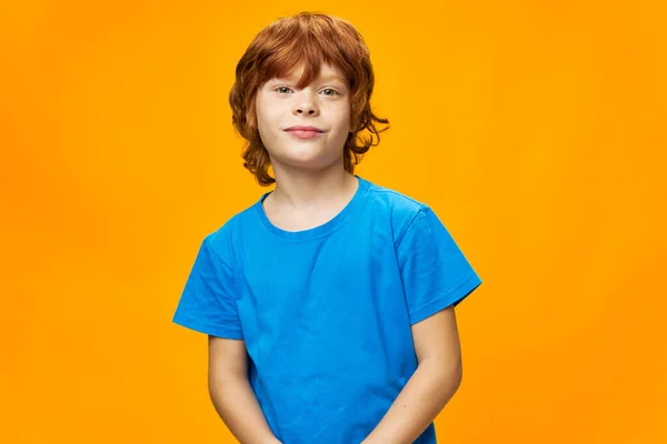 Niño en azul camiseta rojo pelo amarillo fondo hermosa sonrisa —  Fotos de Stock