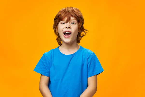 Vacker rödhårig pojke i blå T-shirt med öppen mun — Stockfoto