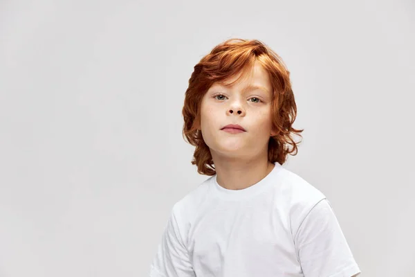 Cute redhead boy in white t-shirt close-up gray isolated — Stock Photo, Image