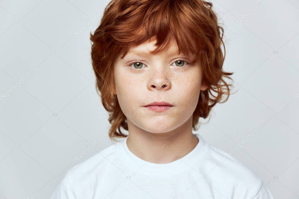 Cute redhead boy freckles on his face cropped view 