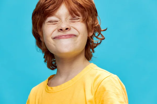 Lächelndes rothaariges Kind mit geschlossenen Augen im gelben T-Shirt — Stockfoto