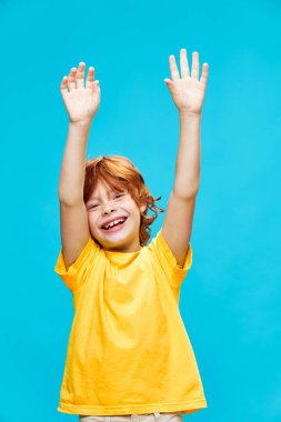 Kolları havada kızıl saçlı çocuk kahkahalar atıyor. 