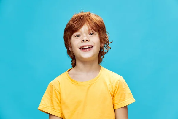 Glad barn med rött hår skrattar på en isolerad blå bakgrund — Stockfoto