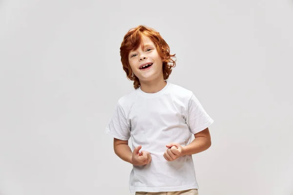 Divertido niño sonrisa blanco camiseta estudio gris aislado — Foto de Stock