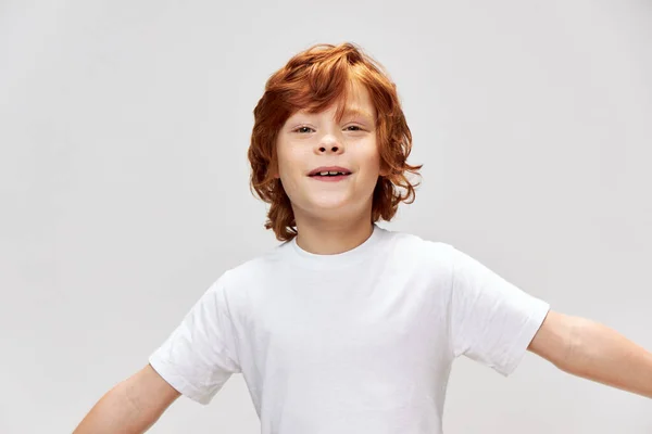 Porträtt av rödhårig pojke kul kastar upp händerna vit t-shirt — Stockfoto