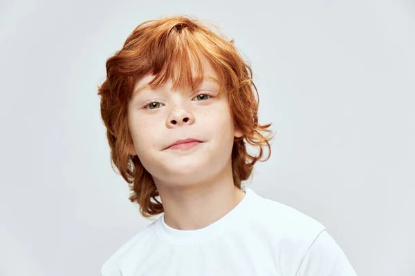 Retrato de ruiva menino rosto close up estúdio recortado vista branco t-shirt — Fotografia de Stock