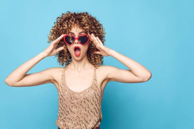 Çekici bir kadın el hareketleriyle izole edilmiş mavi bir arkaplanda