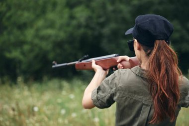 Asker kadın silah avlıyor. Hedef dikiz görüşü yeşil tulum. 