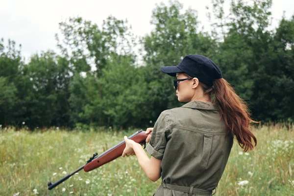 Military woman holding a gun hunting lifestyle green leaves — Stock Photo, Image