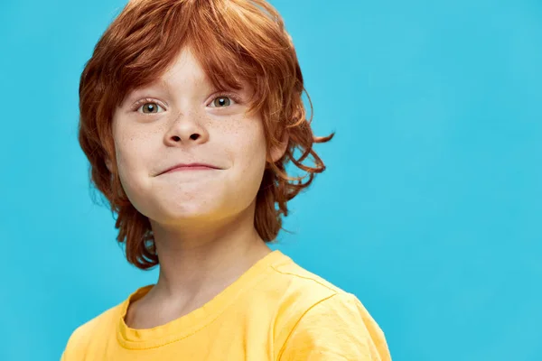 Portrait of a red-haired boy with freckles on a blue background — Stock Photo, Image