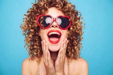 İzole edilmiş mavi arka planda romantik sarışın el hareketleri, peruk. 