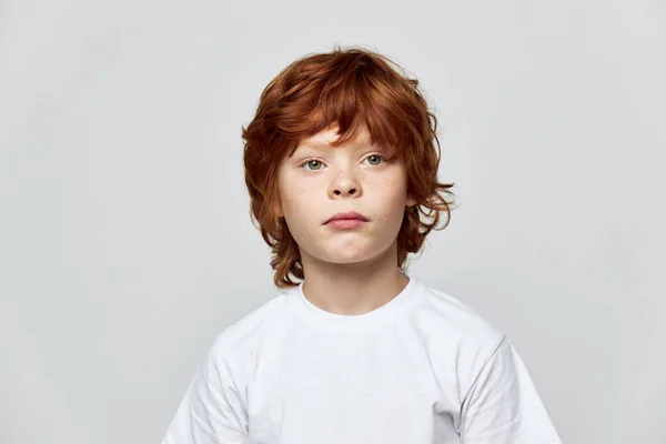 Roodharig kind met sproeten op haar uitgesneden gezicht heeft een wit T-shirt — Stockfoto