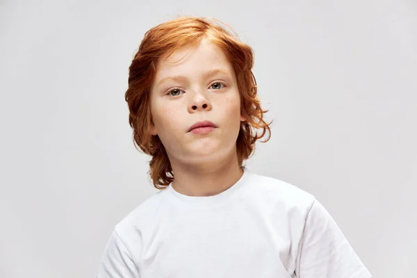 Рыжеволосый ребенок белый футболка серый фон — стоковое фото