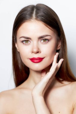 Esmer, açık tenli, çekici kırmızı dudaklı, çıplak omuzlu. 