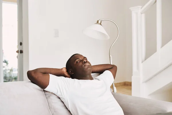 Мужчина сидит дома на диване интерьера отдыха — стоковое фото