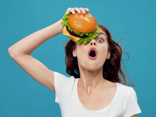 Vrouw met cheeseburger op haar gezicht fast food dieetvoeding close-up — Stockfoto