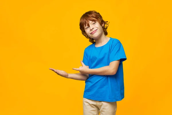 Rödhåriga barn fräknar visa med händerna åt sidan och flina i ansiktet — Stockfoto