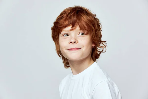 Redhead boy in white t-shirt smile cropped view gray isolated background studio — Stock Photo, Image