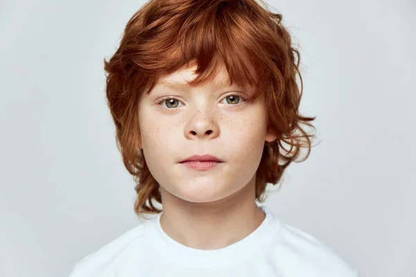 Rödhårig pojke ansikte närbild fräknar i ansiktet beskärd vy grå bakgrund — Stockfoto