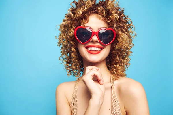 Tatlı kız el hareketleri izole edilmiş mavi bir arka plan, moda güneş gözlükleri 