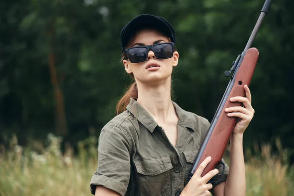 Mujer militar escopeta caza gafas de sol hojas verdes — Foto de Stock