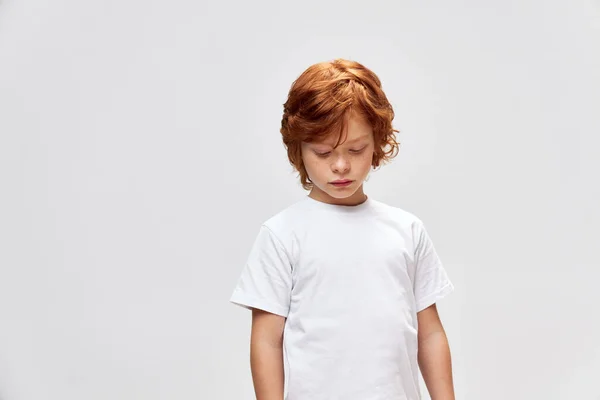 Pelirroja adolescente mirando abajo blanco camiseta recortado ver studio — Foto de Stock
